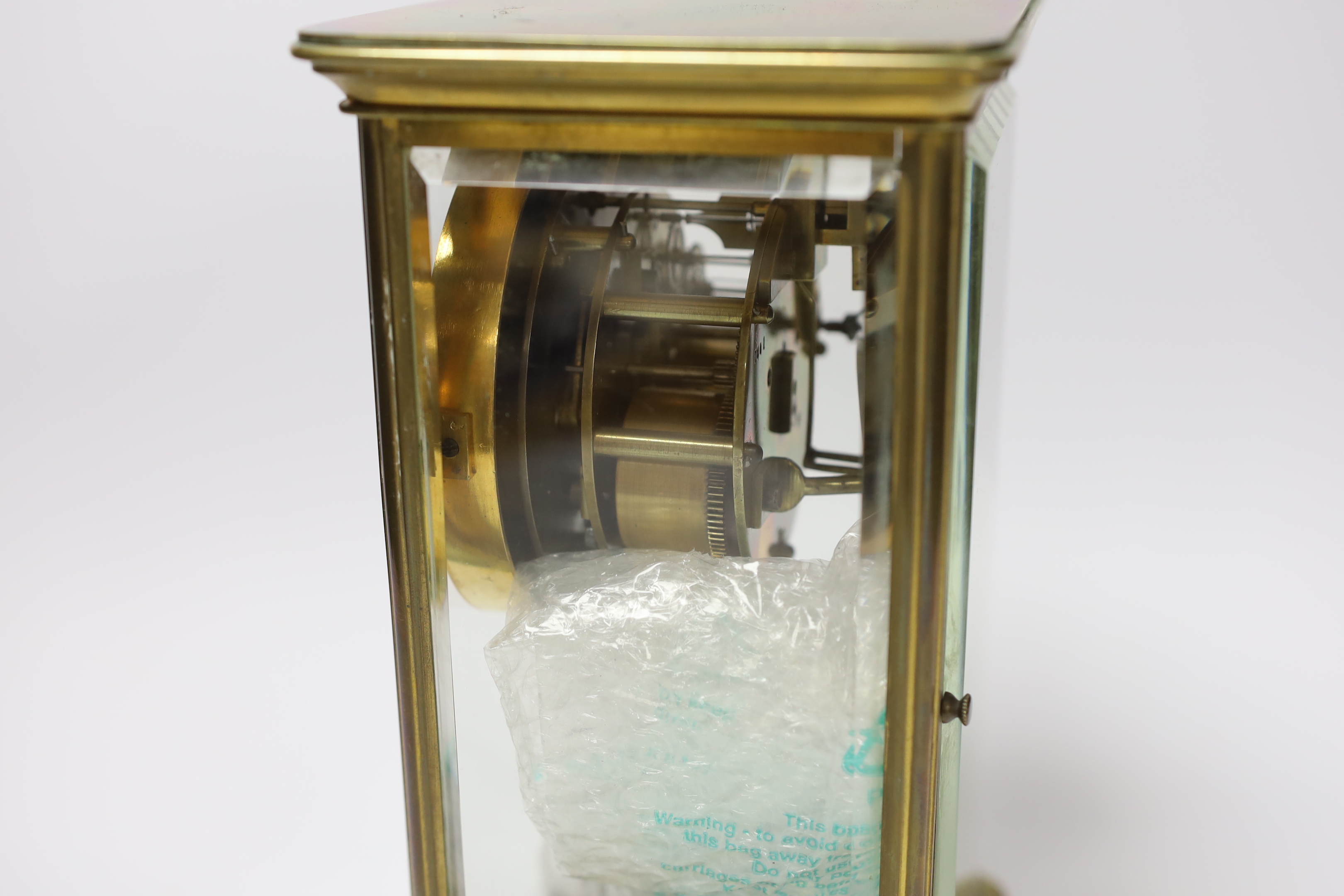 A late 19th century French brass four-glass mantel clock, striking on a bell, engraved to base, with key and pendulum, 27cm